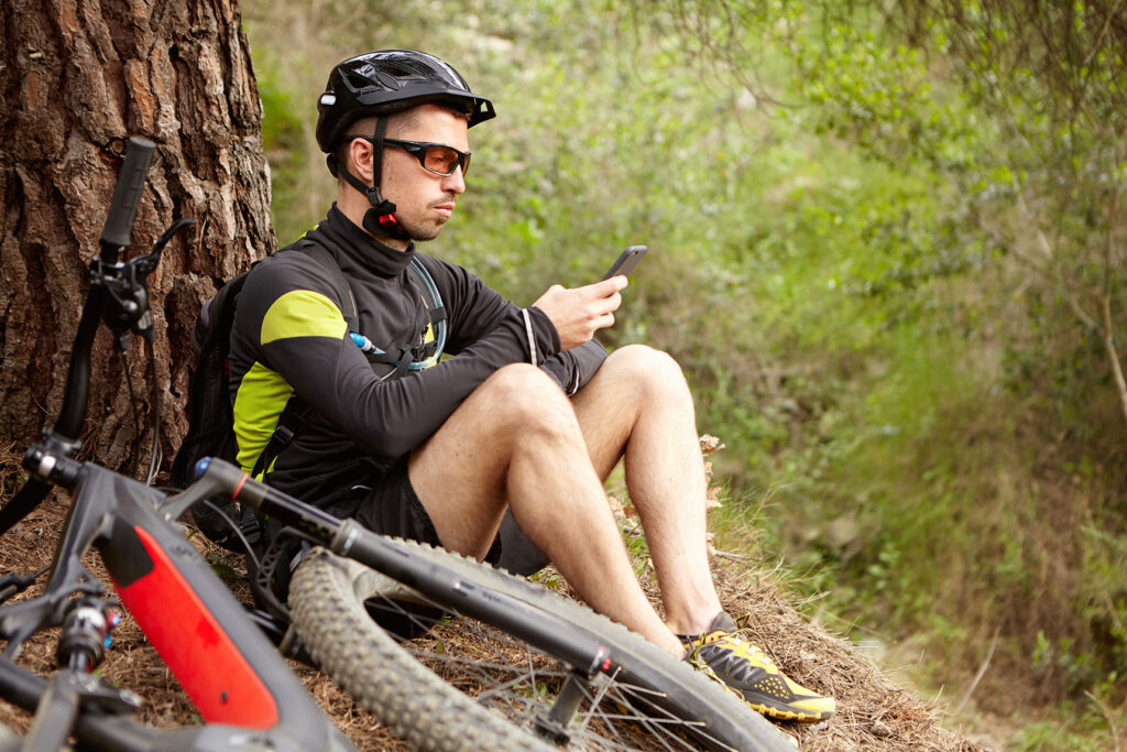 Cycliste en sortie consultant une application GPS sur smartphone monté à la potence